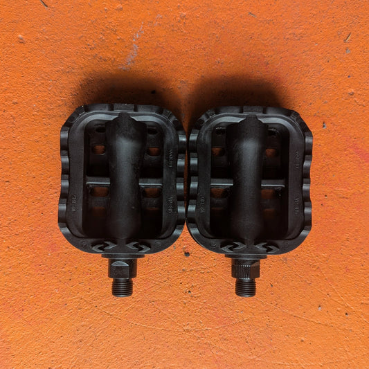 A pair of metal e-bike pedals in a beach cruiser style, featuring a wide, flat platform with textured grip and a durable silver finish.