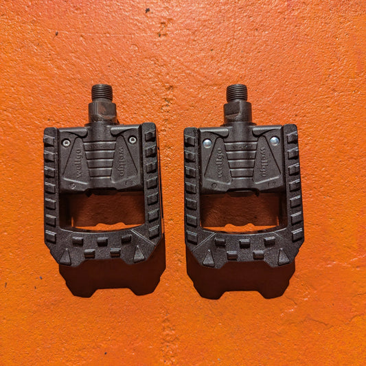 Black nylon folding e-bike pedals with textured surface and compact, space-saving design.