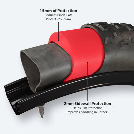 Red Tannus Armour tire liner displayed next to a bicycle tire and inner tube on a white background.