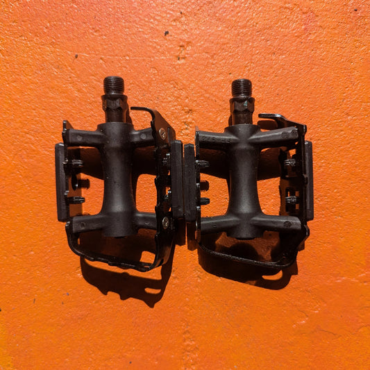 Close-up of metal e-bike pedals in a modern, rugged style, featuring a textured surface and durable construction.