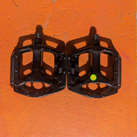 Close-up of metal e-bike pedals with a textured, non-slip surface and a modern, durable design.