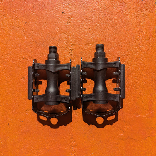 Close-up of metal e-bike pedals in a modern, rugged style, featuring a textured surface and durable construction.